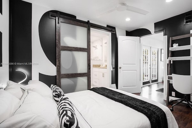 bedroom featuring ensuite bathroom, ceiling fan, wood-type flooring, and a barn door