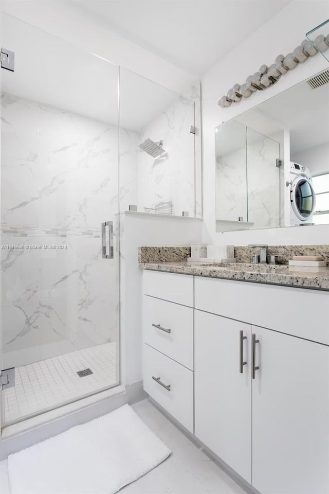 bathroom featuring a shower with shower door, vanity, and tile patterned floors