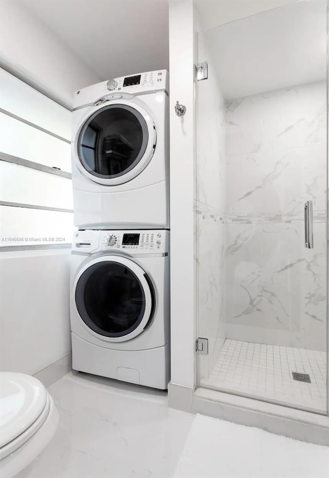 clothes washing area featuring stacked washer / drying machine and light tile patterned flooring