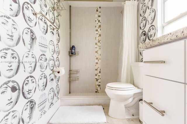 bathroom with a shower with curtain and toilet