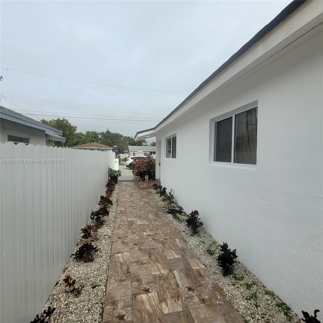 view of side of home with fence and stucco siding