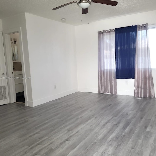 unfurnished room featuring ceiling fan, a textured ceiling, baseboards, and wood finished floors