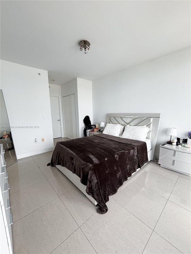 bedroom featuring baseboards and tile patterned floors