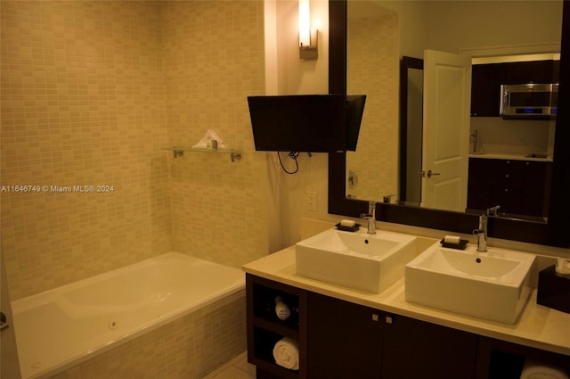 bathroom featuring tile patterned floors, vanity, and a relaxing tiled tub