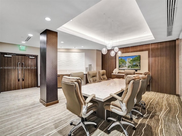 dining space featuring a raised ceiling and light colored carpet