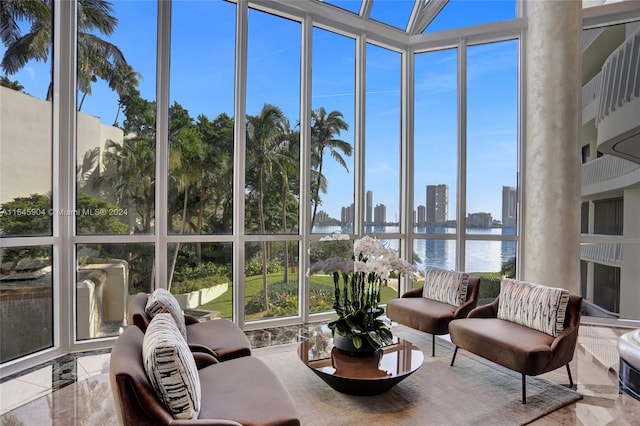 sunroom featuring a wealth of natural light and a water view