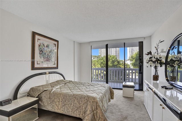 carpeted bedroom with a textured ceiling and access to exterior