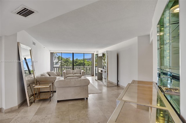 tiled living room with a textured ceiling and a wall of windows