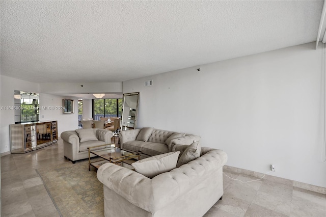 tiled living room featuring plenty of natural light and a textured ceiling