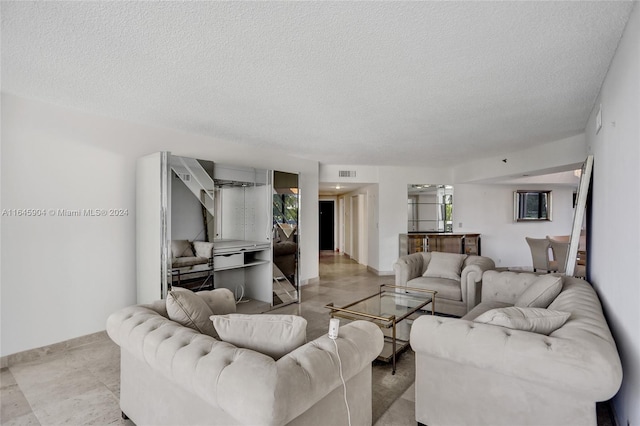 living room with a textured ceiling and light tile patterned flooring