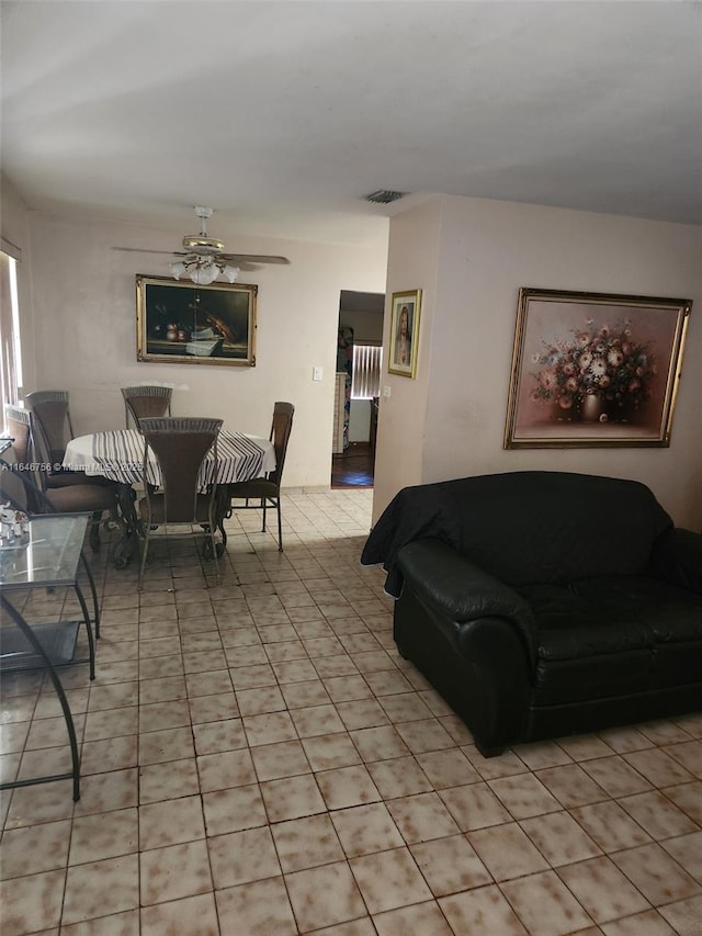 living area featuring visible vents, light tile patterned flooring, and a ceiling fan