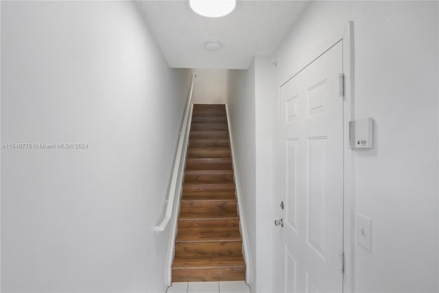 stairway featuring tile patterned flooring