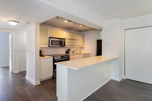 kitchen with kitchen peninsula, decorative backsplash, electric range oven, dark wood-type flooring, and sink