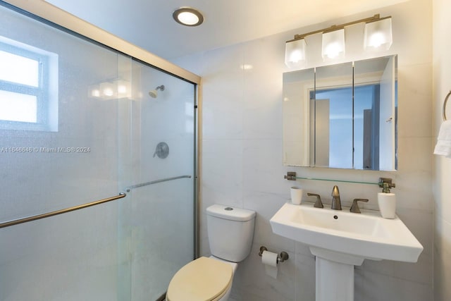 bathroom with a shower with shower door, tile walls, and toilet