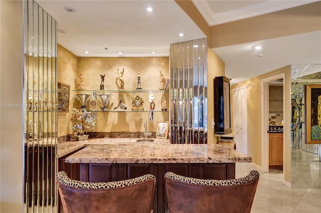 bar with light stone counters and ornamental molding