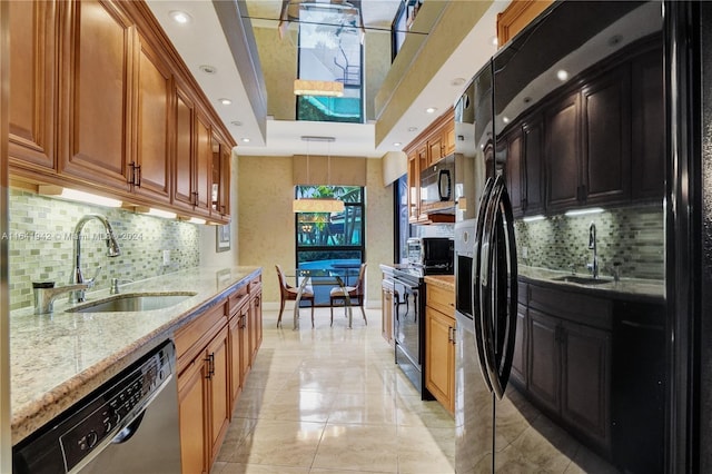 kitchen with stainless steel appliances, backsplash, decorative light fixtures, and sink