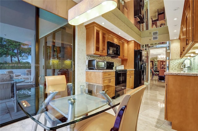 dining space with light tile patterned floors, a towering ceiling, and sink