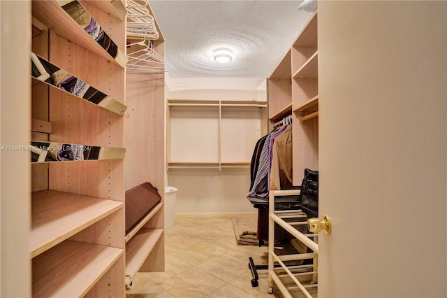 walk in closet with light tile patterned floors