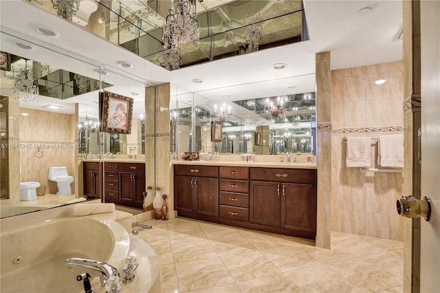 bathroom featuring vanity, a bathing tub, tile patterned flooring, and tile walls