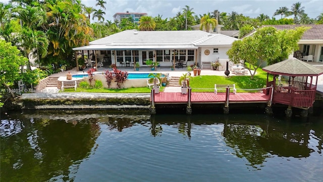 back of house with a gazebo, a water view, and a patio