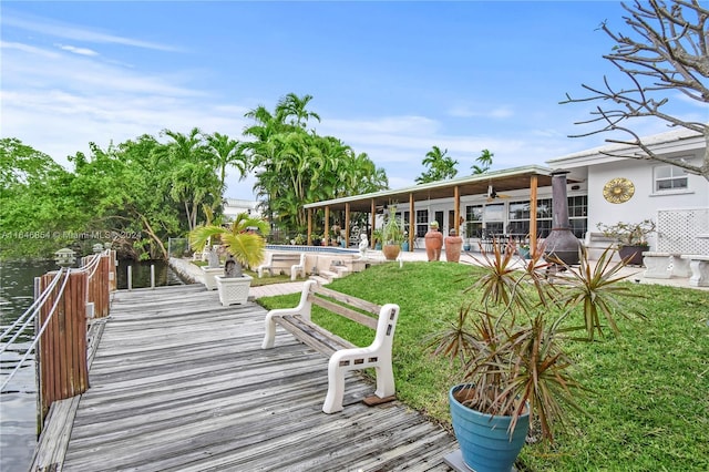 exterior space with a lawn, a patio area, ceiling fan, and a water view