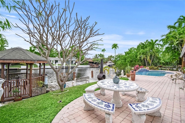 view of patio with a gazebo, a water view, and a dock