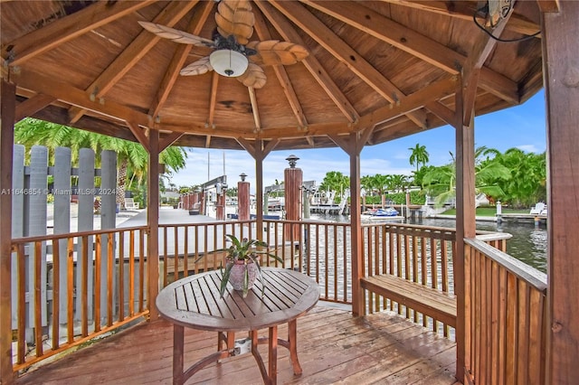 deck with a gazebo, a water view, and ceiling fan