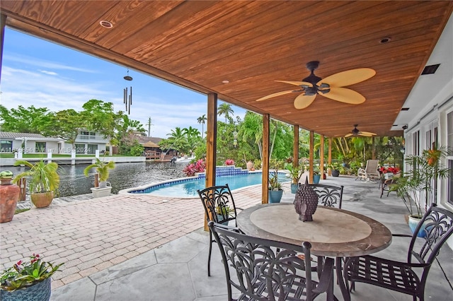 view of patio with ceiling fan and a water view