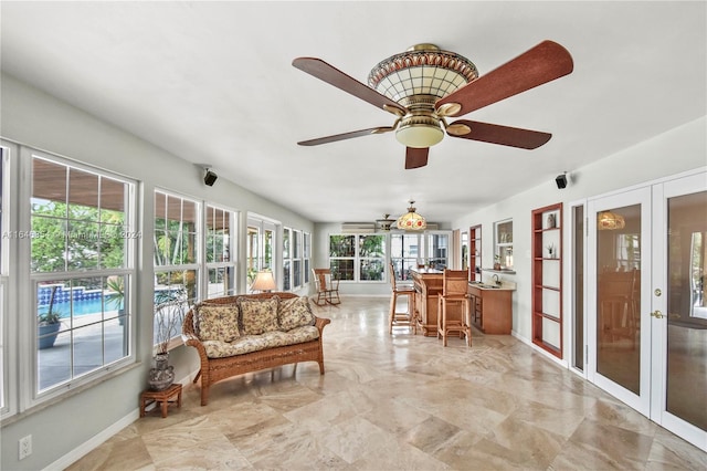 sunroom with french doors, plenty of natural light, and ceiling fan