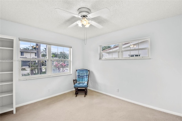 living area with carpet, a textured ceiling, plenty of natural light, and ceiling fan