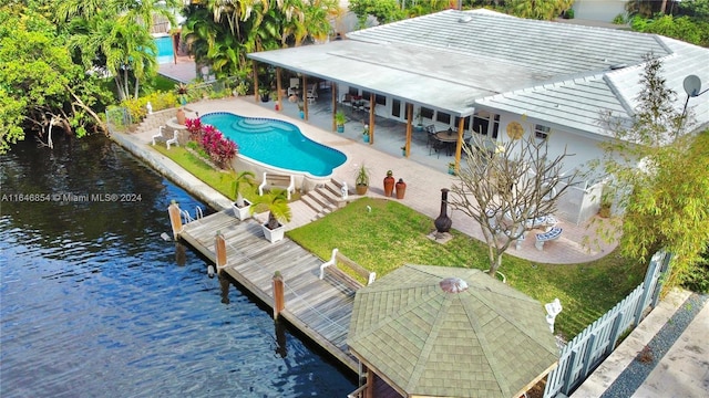 exterior space featuring a water view, a fenced in pool, and a patio area