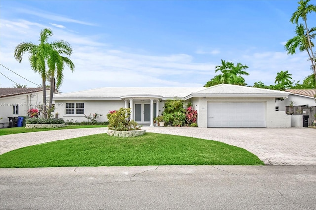 single story home with french doors, a garage, and a front lawn