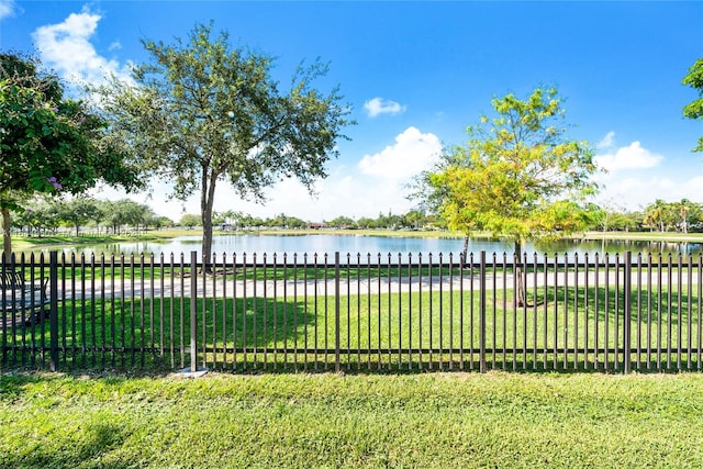 view of gate featuring a water view and a lawn