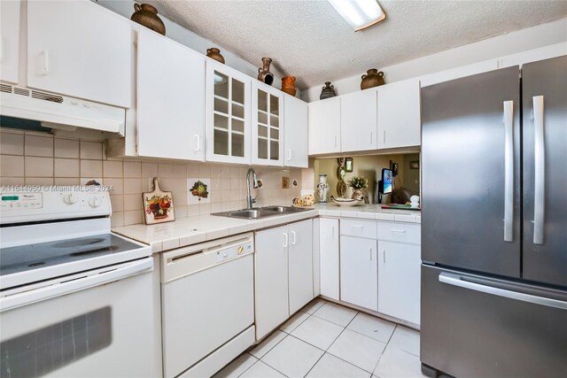 kitchen featuring white cabinetry, white appliances, sink, and decorative backsplash