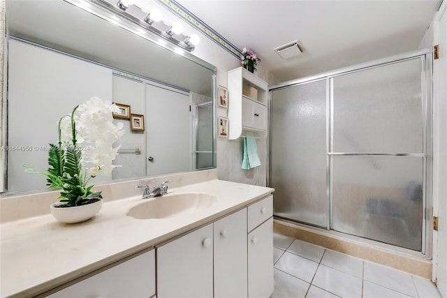 bathroom with tile patterned flooring, vanity, and a shower with door