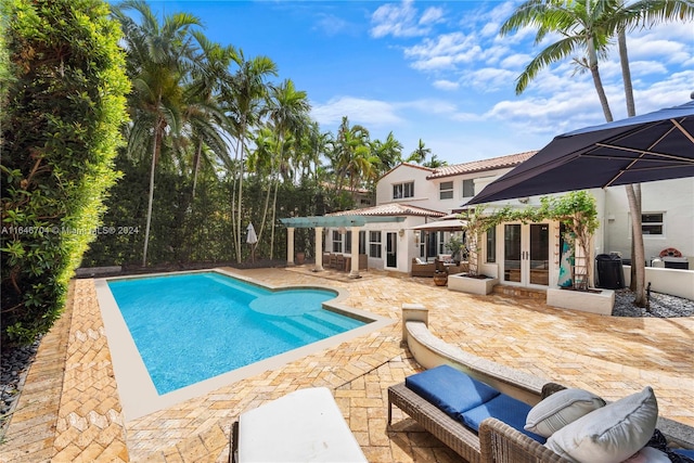 view of swimming pool with french doors and a patio