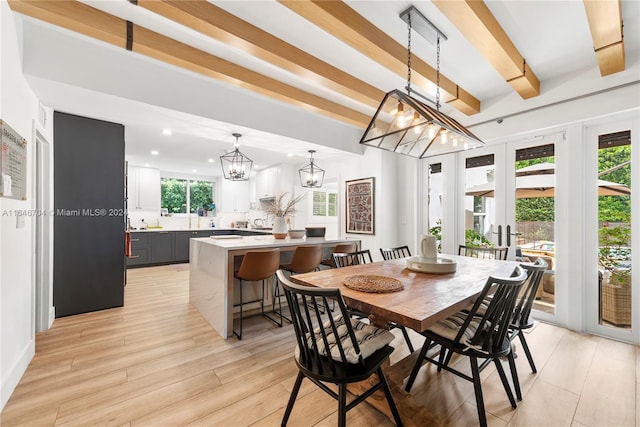 dining space with beam ceiling, sink, light wood-type flooring, and a notable chandelier