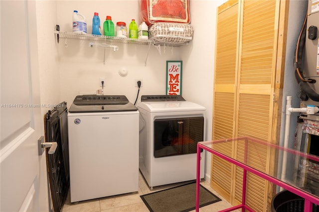 clothes washing area featuring separate washer and dryer and light tile patterned floors