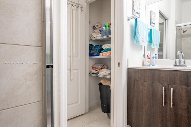 bathroom with vanity, tile patterned floors, and a shower with door