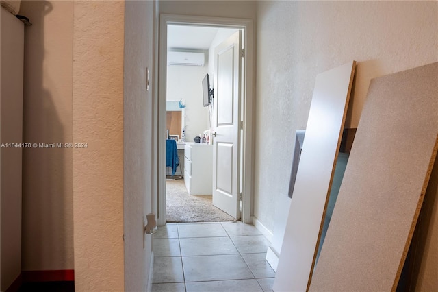 hallway featuring a wall mounted AC and light tile patterned flooring