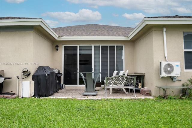 rear view of property featuring ac unit, a patio area, and a lawn