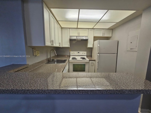 kitchen with dark countertops, white cabinets, a sink, white appliances, and under cabinet range hood