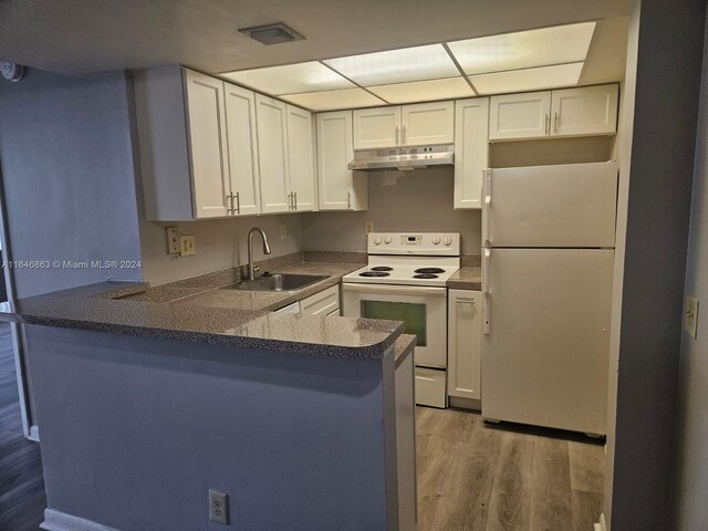 kitchen featuring hardwood / wood-style floors, white cabinets, sink, kitchen peninsula, and white appliances