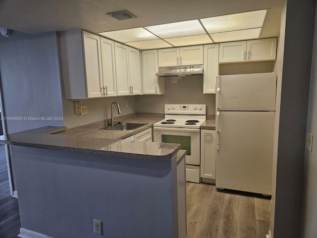 kitchen featuring white cabinetry, a sink, a peninsula, white appliances, and under cabinet range hood