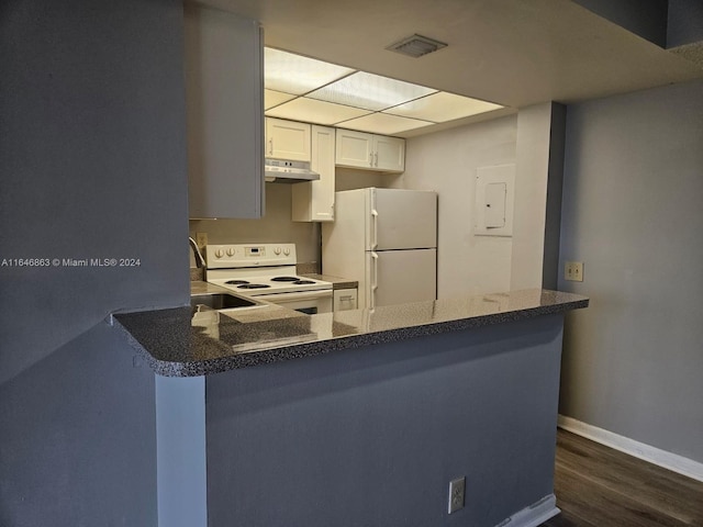 kitchen with dark stone countertops, dark wood-type flooring, white appliances, kitchen peninsula, and white cabinets