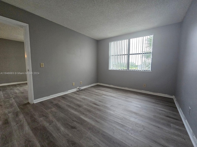 spare room with a textured ceiling and wood-type flooring