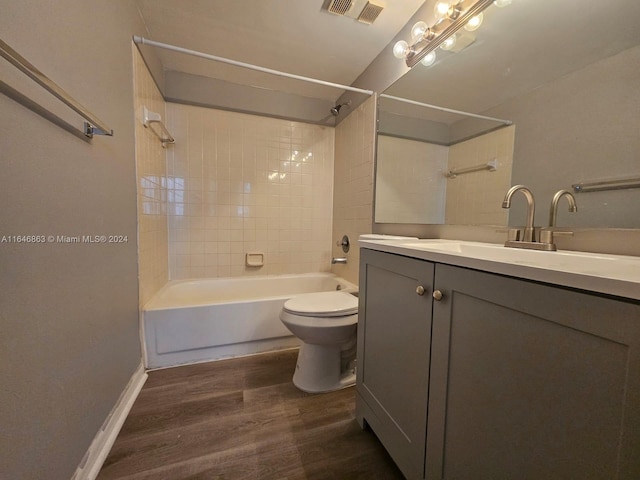 bathroom featuring visible vents, bathing tub / shower combination, toilet, wood finished floors, and vanity