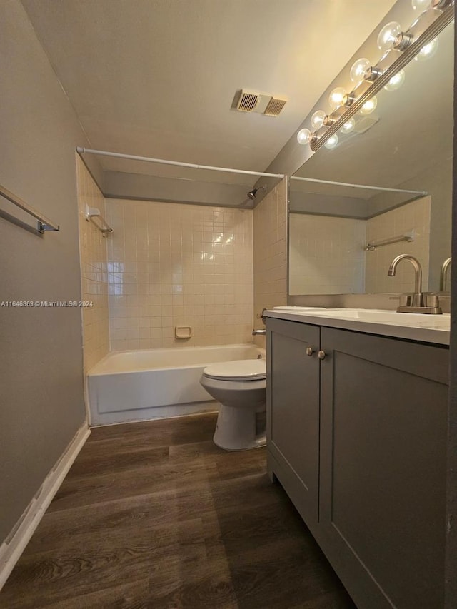 bathroom featuring toilet, shower / bath combination, wood finished floors, vanity, and visible vents