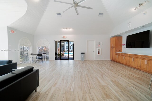 living room with ceiling fan, track lighting, light wood-type flooring, and lofted ceiling