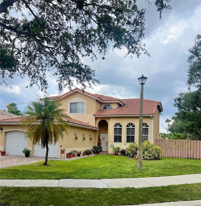 mediterranean / spanish-style home featuring a front yard and a garage